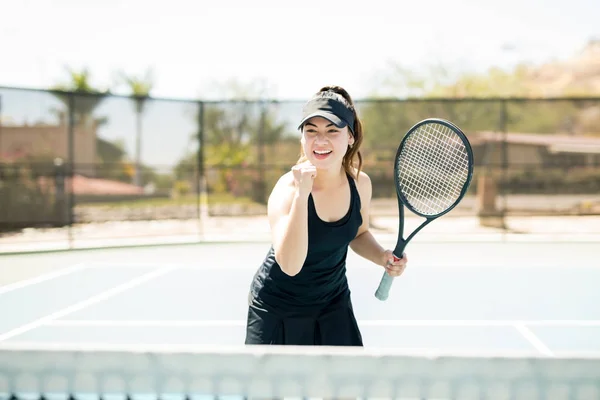 屋外テニスコートのセットに勝った後のくいしばられた握りこぶしでかなり若い女性テニス プレーヤー — ストック写真