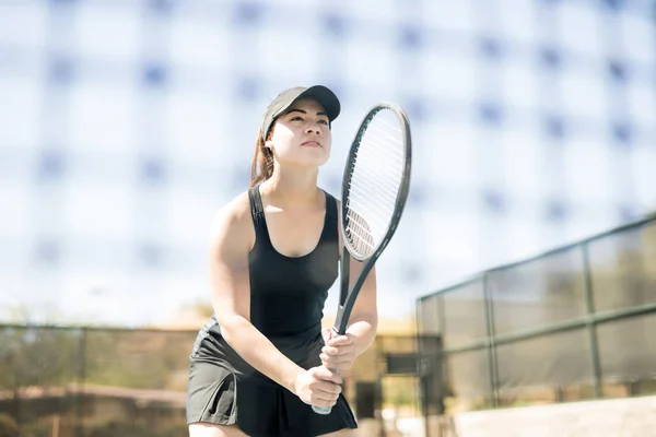 自信的年轻女子网球运动员与球拍站在网上的法院 — 图库照片