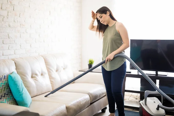Attractive Tired Woman Hoovering Sofa Using Vacuum Cleaner — Stock Photo, Image