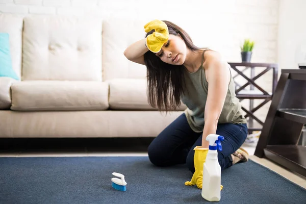 Giovane Donna Sfregamento Testa Indossando Casuals Guanti Gialli Tappeto Pulizia — Foto Stock