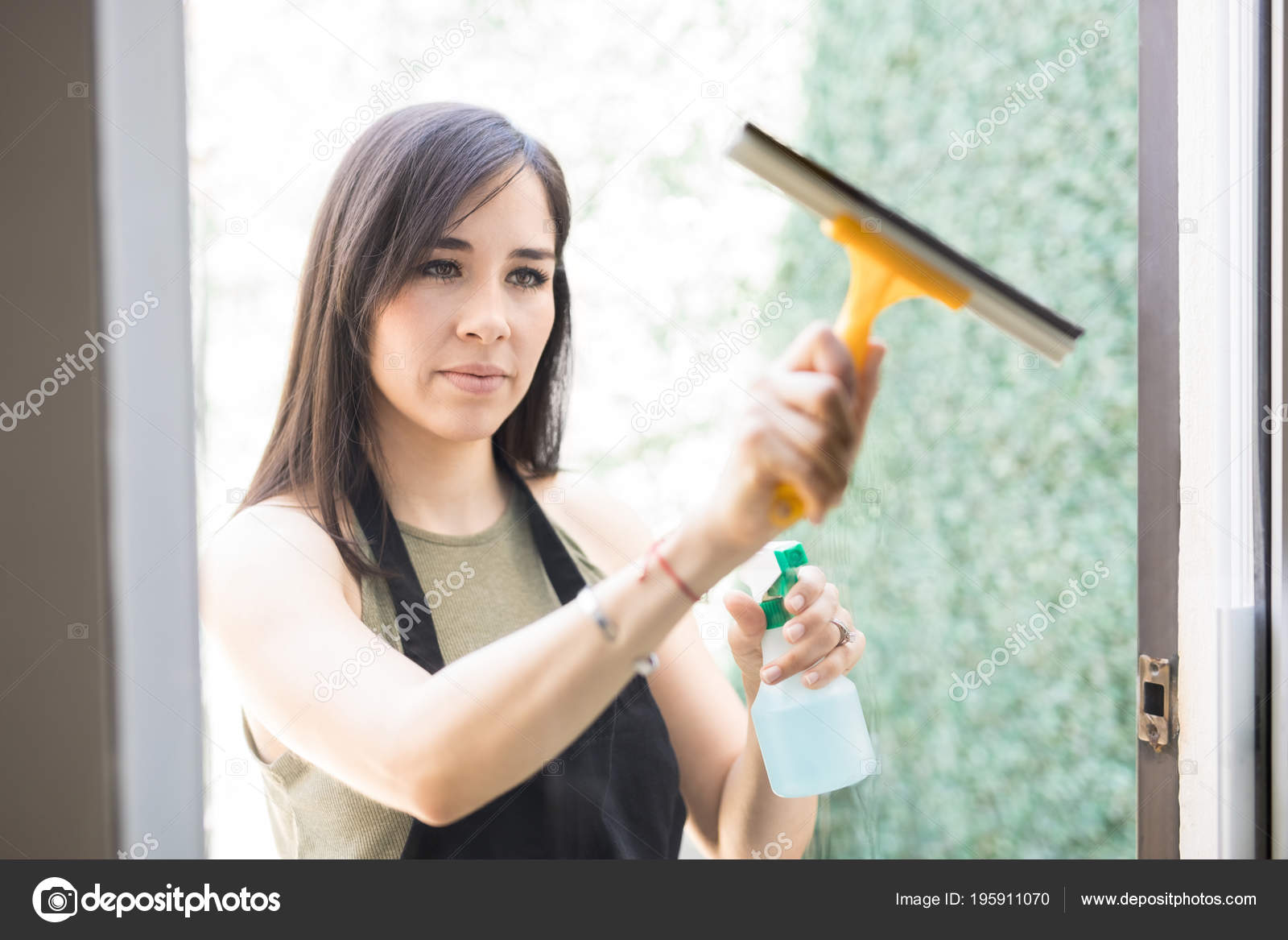 Retrato Joven Mujer Latina Enfocada Limpiando Ventana Cristal Con Spray
