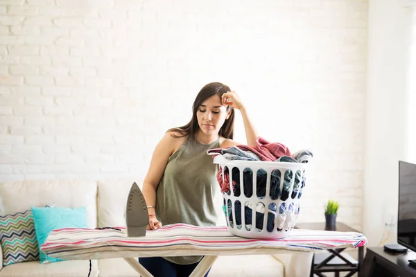 Enttäuschte Unglückliche Hausfrau Lehnt Auf Wäschestapel Auf Bügelbrett — Stockfoto