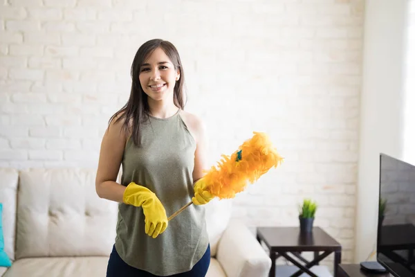 手持橙色合成羽毛除尘器的快乐清洁女工 — 图库照片