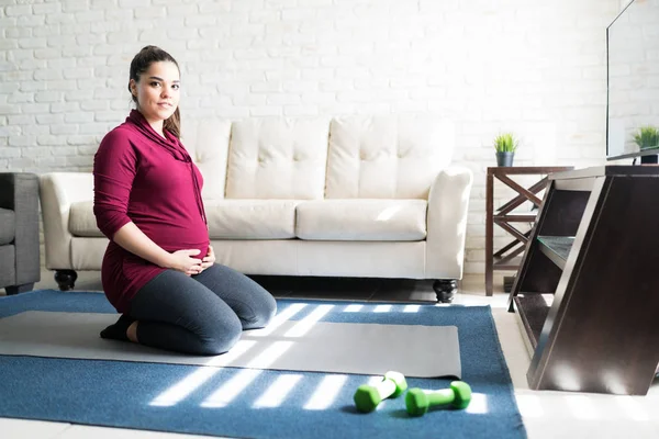 Jolie Femelle Enceinte Agenouillée Sur Tapis Tout Établissant Contact Visuel — Photo