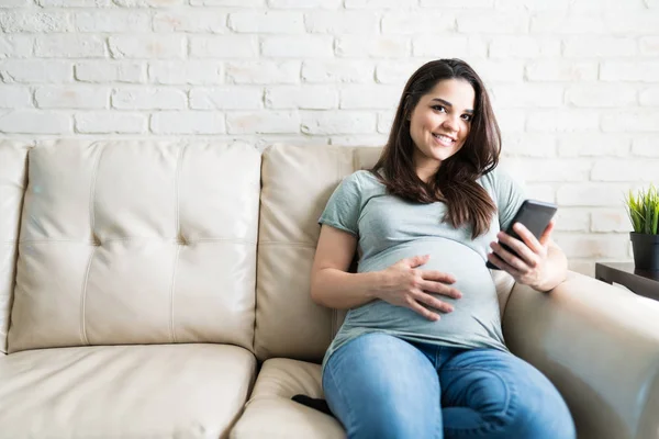 Wunderschöne Schwangere Frau Lächelt Und Entspannt Mit Handy Während Sie — Stockfoto