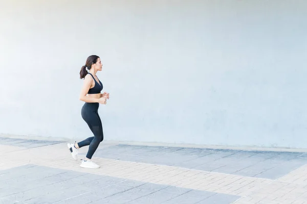 Zijaanzicht Van Blanke Vrouwelijke Atleet Joggen Door Muur Voetpad — Stockfoto