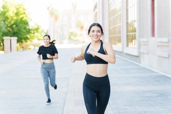 Wspaniałe Uśmiechnięte Kobiety Sportowców Biegnie Wyścigu Piechotę Poprzez Budowę — Zdjęcie stockowe