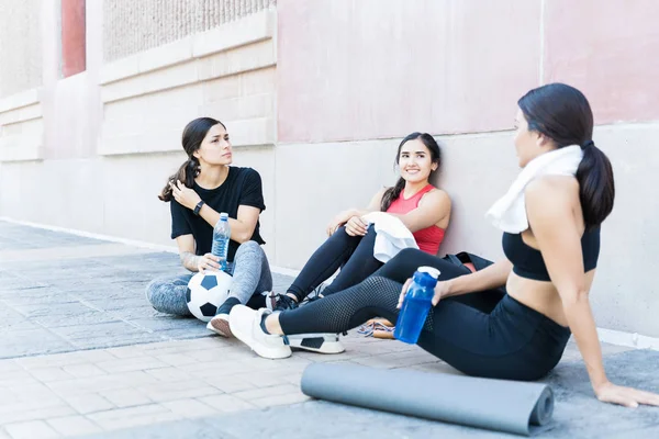 Giovani Amiche Multietniche Che Parlano Mentre Rilassano Dopo Essersi Esercitate — Foto Stock