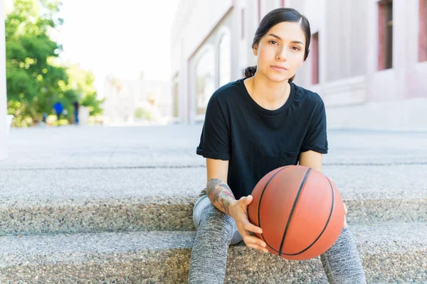 在城市里 年轻而自信的漂亮女子坐在台阶上打篮球 — 图库照片