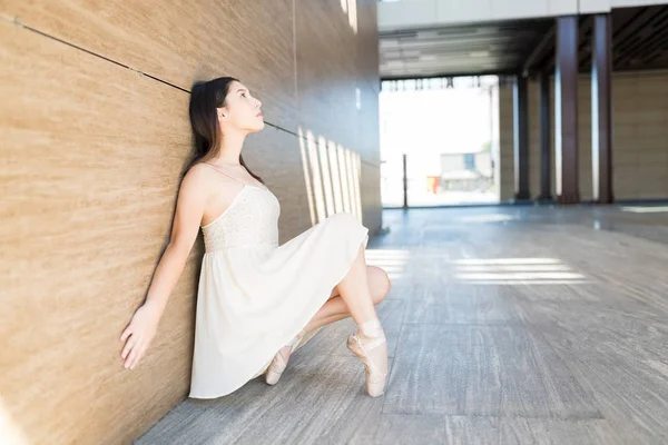 Nachdenkliche Tänzerin Balanciert Kleid Mit Zehenspitzen Auf Straße Gegen Holzwand — Stockfoto