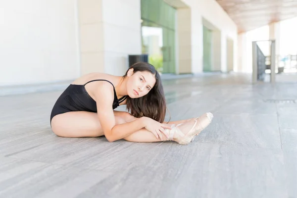 Mooie Ballerina Het Maken Van Oogcontact Terwijl Stretching Stedelijke Scène — Stockfoto