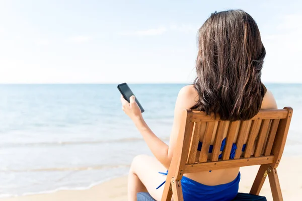 Visão Traseira Mulher Usando Telefone Celular Enquanto Relaxa Cadeira Praia — Fotografia de Stock