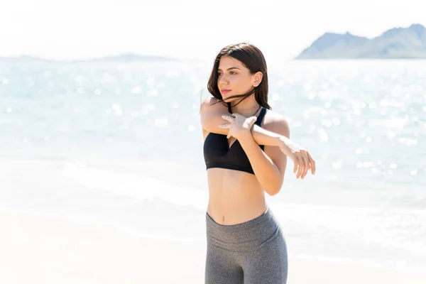 Déterminé Jeune Femme Étirant Bras Tout Tenant Sur Plage — Photo