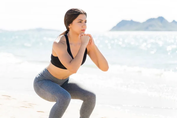 Hermosa Mujer Haciendo Sentadillas Orilla Del Mar Playa Durante Las —  Fotos de Stock