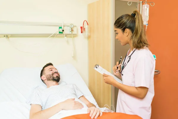 Médico Hispânico Segurando Prancheta Enquanto Explica Relatório Médico Para Paciente — Fotografia de Stock