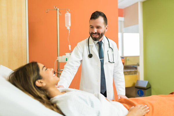 Latin male doctor comforting female patient in hospital