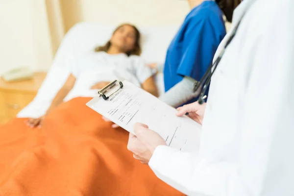 Arts Onderzoekt Medisch Rapport Terwijl Vrouwelijke Zorgverlener Patiënt Het Ziekenhuis — Stockfoto