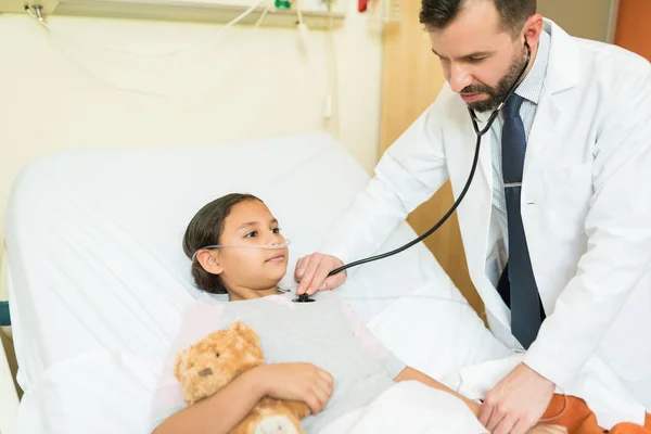 Médico Examinando Chica Con Estetoscopio Mientras Está Acostado Cama Hospital — Foto de Stock