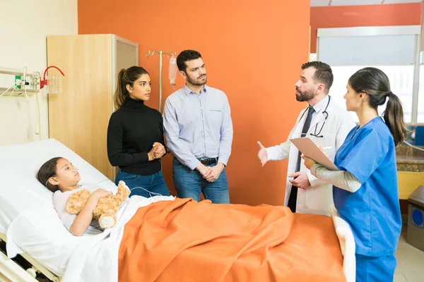 Médico Enfermera Explicando Enfermedad Los Padres Mientras Está Junto Hija — Foto de Stock