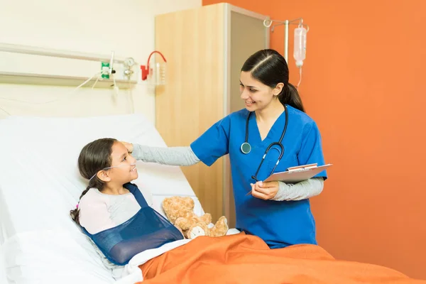 Sonriente Trabajador Salud Sosteniendo Informes Mientras Mira Pequeño Paciente Con — Foto de Stock