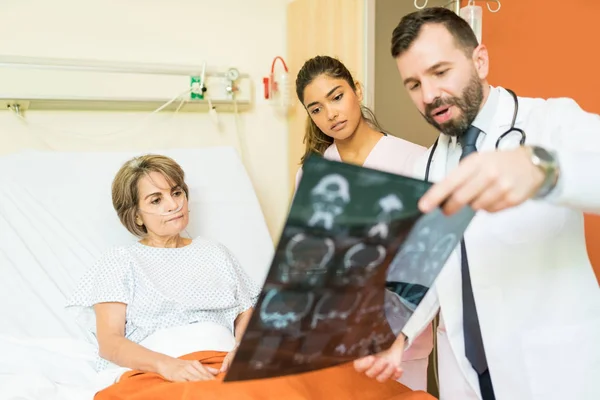 Male Female Healthcare Workers Explaining Xray Diagnosis Senior Patient Suffering — Stockfoto