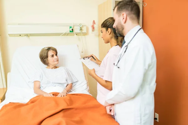 Senior Patient Talking Female Male Healthcare Workers Standing Bed Hospital — Stock Photo, Image