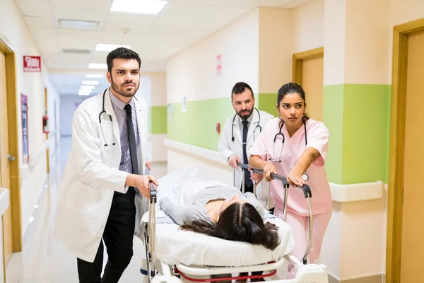 病院の廊下で患者を押し付ける心配のある医者と看護師 — ストック写真