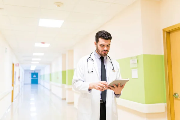 Hispanic Male Doctor Examining Medical Report Digital Tablet While Walking — Stock Photo, Image