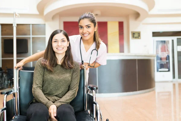 Lächelnde Seniorin Mit Junger Frau Rollstuhl Der Lobby Des Krankenhauses — Stockfoto