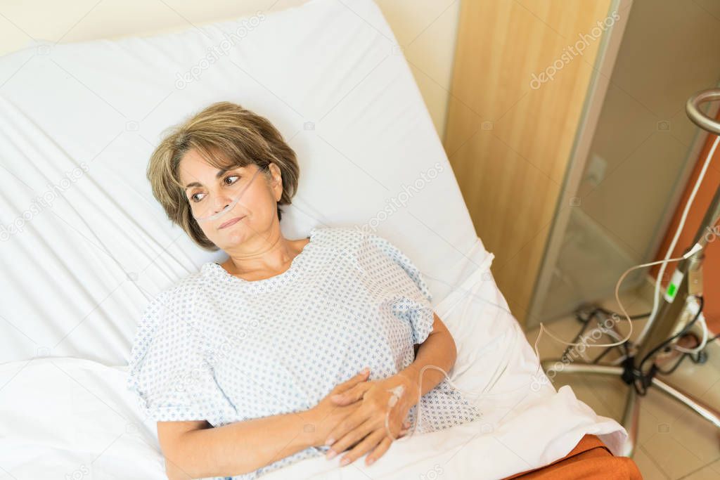 High angle view of thoughtful senior patient  while lying on hospital bed