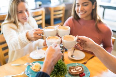 Genç arkadaşlar kahve içerken kahve fincanları kızartıyorlar.