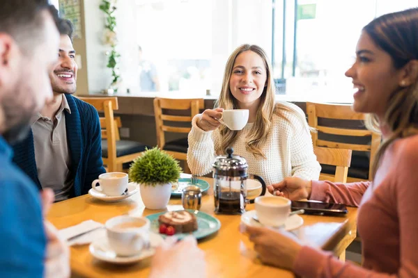 コーヒーを飲みながら友達とレストランのテーブルに座る白人女性 — ストック写真