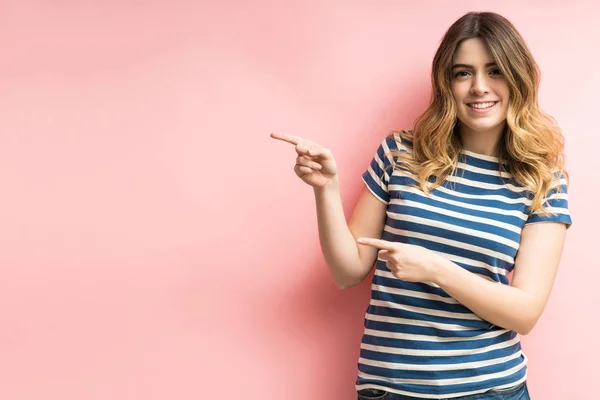 Glimlachende Goed Uitziende Vrouw Wijzend Naar Kopieerruimte Tegen Roze Achtergrond — Stockfoto