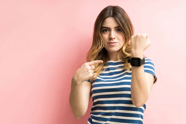 Confident Young Woman Showing Her Smartwatch While Standing Colored Background — Stok fotoğraf