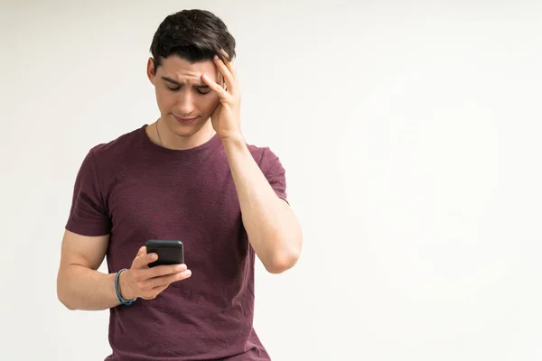 Розчарований Кавказький Чоловік Читає Погані Новини Мобільному Телефону Білому Фоні — стокове фото