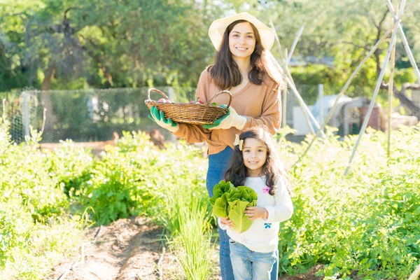 Young Woman Her Daughter Holding Organic Vegetables While Standing Garden — 스톡 사진