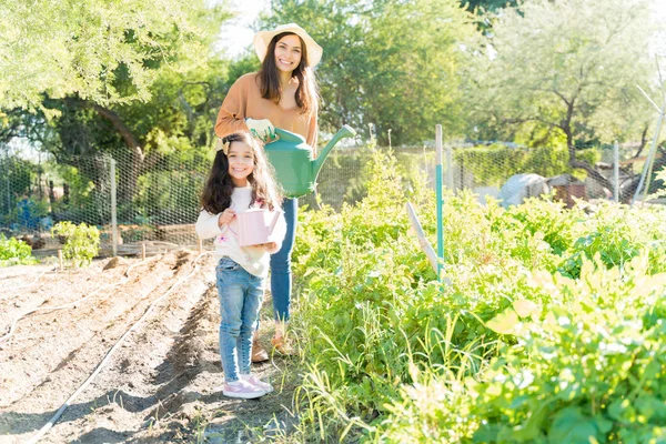 Smiling Mother Daughter Holding Watering Cans While Standing Plants Farm — 스톡 사진