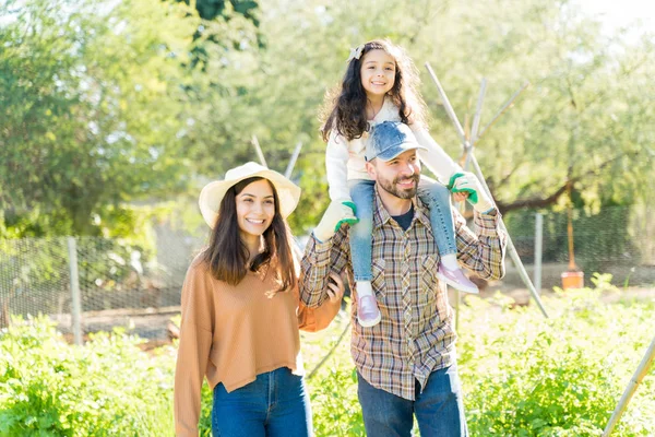 Smiling Latin family walking together in farm during summer