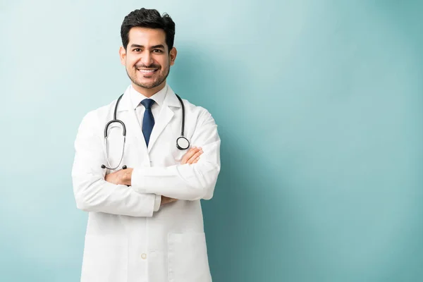 Sorrindo Médico Hispânico Com Braços Cruzados Contra Fundo Azul — Fotografia de Stock