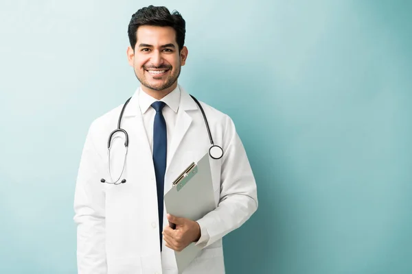Lächelnder Junger Arzt Mit Klemmbrett Vor Farbigem Hintergrund — Stockfoto