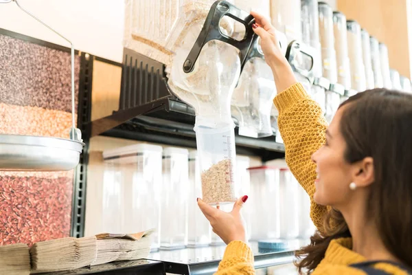 Jovem Mulher Adulta Derramando Cereal Recipiente Enquanto Compra Granel Mercearia — Fotografia de Stock