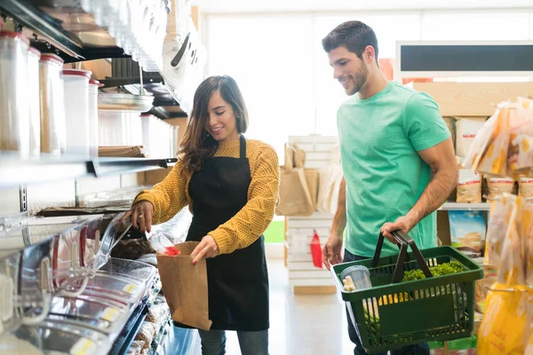 Lächelnde Arbeiterin Legt Lebensmittel Papiertüte Für Jungen Mann Supermarkt — Stockfoto