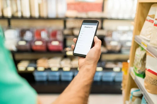 Cropped Image Young Man Checking Shopping List Smartphone Grocery Store — Stok fotoğraf