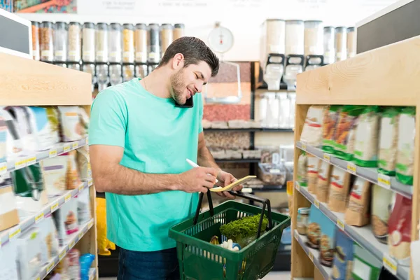 Sorrindo Cliente Masculino Verificando Lista Compras Falar Smartphone Supermercado — Fotografia de Stock