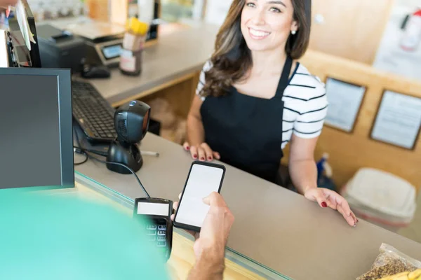 Selbstbewusste Kassiererin Erhält Bezahlung Smartphone Lebensmittelgeschäft — Stockfoto