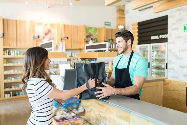 Confident Male Cashier Giving Bag Woman Checkout Counter Grocery Store — Stock Photo, Image
