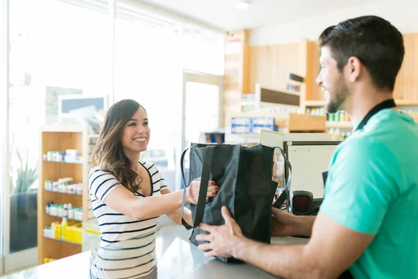 Male Cashier Giving Bag Smiling Woman Checkout Counter Supermarket — Stockfoto