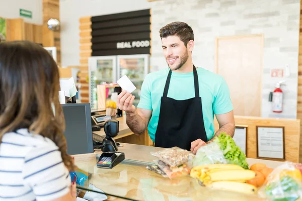 Lächelnder Männlicher Besitzer Übergibt Der Kasse Supermarkt Belohnungskarte Käufer — Stockfoto