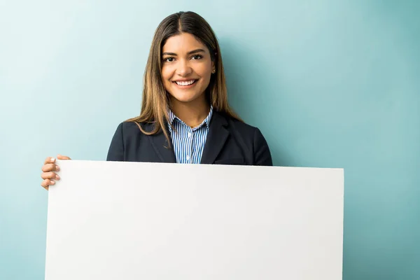 Smiling Latin Businesswoman Holding Blank Placard While Standing Studio — 스톡 사진