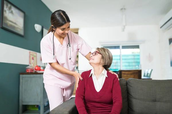 Smiling Young Nurse Talking Senior Woman Sitting Sofa Home — Stock Photo, Image